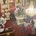 A line of communicants proceeds up the center aisle of the church towards the iconostas to receive communion from Father Aleksey.