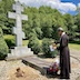 Fr. Aleksey blesses the grave of Fr. Dedick (See the history page for more information about Fr. Dedick!). The grave has a concrete slab with a bouquet of flowers in front of it and a large granite cross behind it. A depiction of the body of Christ is engraved on the cross, which stands atop of a pedestal that has three steps on either side of the cross, kind of like an Olympic medal platform. An inscription engraved onto the front of the platform reads St. Michael's Russian Orthodox Cemetery 1957.