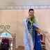 Fr. Aleksey appears at the top of the stairs in the choir loft and appears to be blessing the choir with a bunch of basil that has been dipped into holy water. His right hand is holding the basil and is outstretched towards the camera, while his other hand holds a gold chalice of holy water.