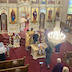 A view from the choir loft showing congregants receiving communion. Several people are visible in line to receive communion.