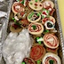 Colorful cookies in an aluminum tray! Some cookies in the lower left part of the tray are wrapped in waxed paper to prevent their powdered sugar from getting all over the other cookies.